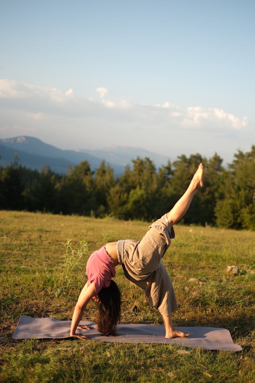 Imagen de una cliente realizando yoga en un paisaje de montaña tras haberla seleccionado en el catalogo de experiencias wellness de Alps Senses
